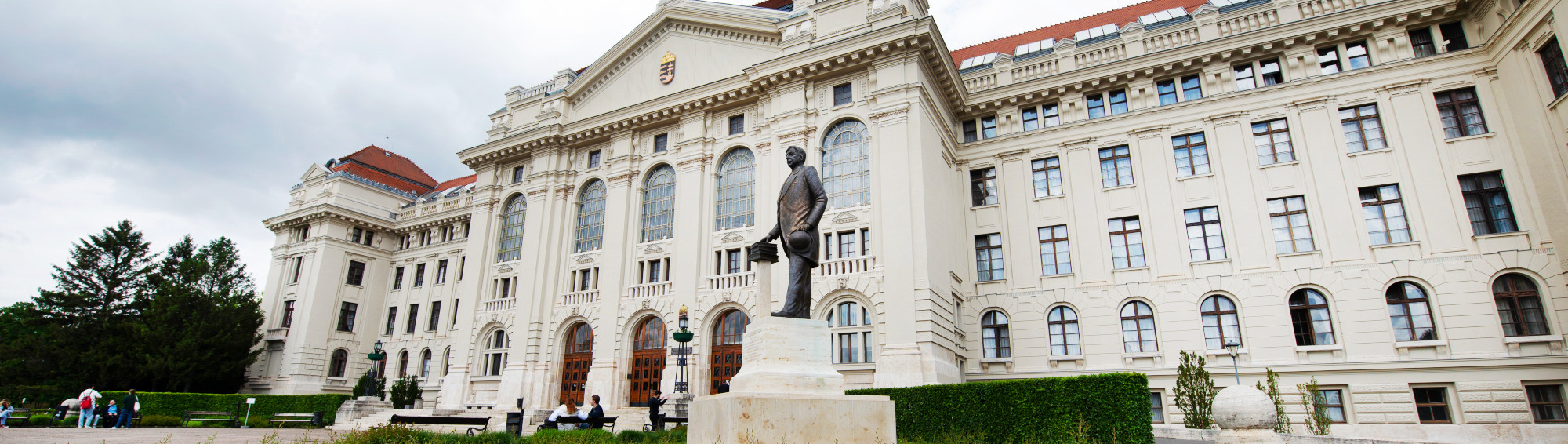 University Main Building main entrance with flowers and statue.