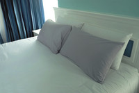 Detail of hotel room showing comfortable bed with pillows. 