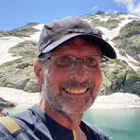 Portrait of Mark Priestley in front of a mountain.