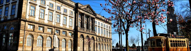 Old Building University of Porto with cherry tree and pictoresque bus in front.